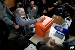 El expresidente José “Pepe” Mujica emite su voto en una urna durante una jornada para elegir presidente, vicepresidente, senadores y diputados, en Montevideo. (AP/Natacha Pisarenko)