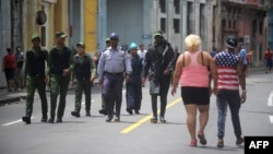 Policías y guardias caminan por una calle de La Habana.