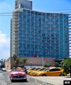 El conductor de un auto clásico espera turistas a las afueras de un hotel de La Habana.