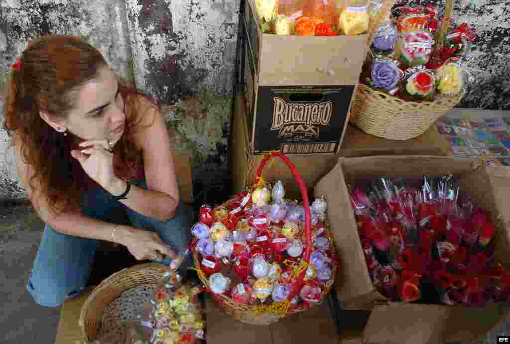 Una mujer vende flores de plástico en un puesto callejero en el popular barrio de Centro Habana. Flores artificiales y plumas.