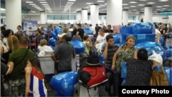 Los cubanos que viajan a Cuba en el aeropuerto de Miami se identifican por su abundante equipaje.