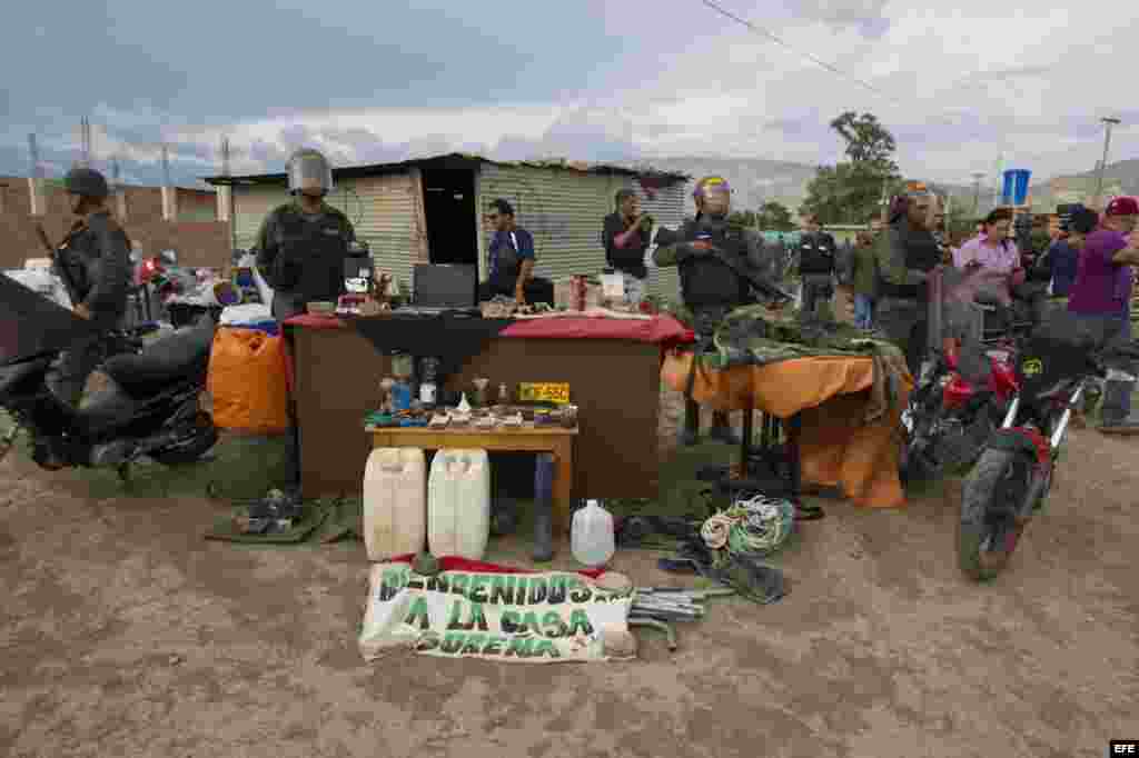 Fotografía cedida hoy, domingo 23 de agosto de 2015, por la Vicepresidencia de Venezuela donde se observa a miembros de la Guardia Nacional Bolivariana (GNB) custodiar objetos de una requisa efectuada en la localidad La Invasión en Táchira (Venezuela).