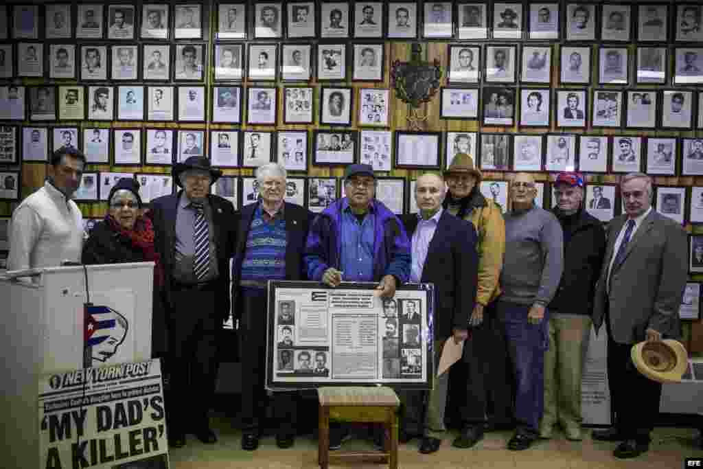 Miembros de la Unión de expresos políticos cubanos de Nueva Jersey posan frente a un gran exposición de prisioneros, víctimas y represaliados políticos del castrismo