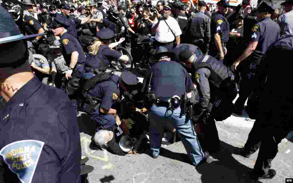 Un grupo de manifestantes es detenido por la policía luego de quemar una bandera de EE.UU. cerca a la entrada a Quicken Loans Arena, sitio donde se realiza la Convención Nacional Republicana.