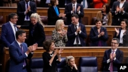 El presidente del gobierno español, Pedro Sánchez y la vicepresidenta María Jesús Montero en el Congreso de Diputados, en Madrid, el 14 de marzo de 2024, celebran la aprobación del proyecto de ley de amnistía a separatistas catalanes. (AP Foto/Manu Fernandez)