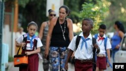  Tres niños posan con una bandera cubana durante el primer día del curso escolar 2015-2016 hoy, martes 1 de septiembre de 2015, en La Habana (Cuba). Cuba comienza hoy el curso escolar 2015-2016 con cerca de dos millones de estudiantes en más de 10.300 esc