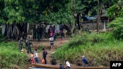 Venezolanos abordan botes para cruzar el río Arauca desde La Victoria, estado Apure, Venezuela, hasta el municipio de Arauquita, departamento de Arauca, Colombia. 