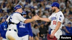 El pitcher de los Dodgers, Alex Vesia (51) y el catcher Will Smith (16) celebran el triunfo de este sábado frente a los Yankees. (Jayne Kamin-Oncea-Imagn Images vía Reuters)