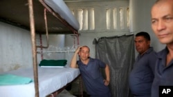 Tres prisioneros de la cárcel Combinado del Este en la Habana, Cuba, durante una visita de periodistas el 9 de Abril de 2013. (AP Foto/Franklin Reyes)