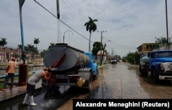 Un conductor se refresca mientras llena el tanque de un camión de agua en La Habana, Cuba, el 3 de julio de 2023. REUTERS/Alexandre MeneghiniArchivo