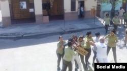 Micaela Roll Gibert (derecha) en una foto de archivo cuando era arrestada por mujeres policías frente a la sede de las Damas de blanco en La Habana. (Facebook).