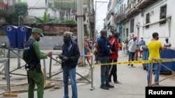 Un policía pide documentos a los residentes en un barrio en cuarentena por coronavirus en La Habana. REUTERS/Stringer