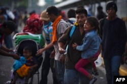 Familias enteras con niños pequeños viajan en la caravana con rumbo a EEUU.