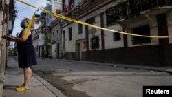 Una trabajadora de salud hace preguntas a los vecinos de un barrio en cuarentena por COVID-19, en La Habana. (REUTERS/Alexandre Meneghini)