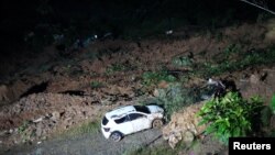 Un automóvil dañado entre escombros después de un deslizamiento de tierra causado por fuertes lluvias en Chocó, Colombia, el 13 de enero de 2024. Yordy Moreno/Gobierno de Chocó/Folleto vía REUTERS