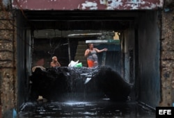 Cubanos se recuperan hoy, miércoles 5 de octubre de 2016, de los destrozos y estragos causados por el paso del huracán Matthew en Baracoa, provincia de Guantánamo (Cuba). El huracán Matthew dejó a su paso por Cuba graves destrozos en el extremo oriental d