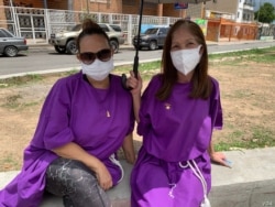 Yamile Urtrera, ciudadana consultada, espera junto a su hermana el paso de la imagen del Nazareno de San Pablo en Caracas, Venezuela. Marzo 31, 2021. Foto: VOA.