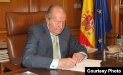 Foto de la Casa Real Española. Juan Carlos I firma la abdicación al trono.