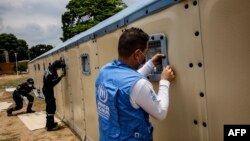 Un trabajador de la comisión de refugiados de Naciones Unidas (UNHCR, por sus siglas en inglés) prepara un hospital provisional para venezolanos aquejados del COVID-19 en el lado colombiano de la frontera Venezuela-Colombia en Cúcuta (Schneyder Mendoza/AFP).