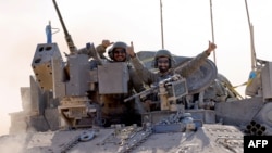 Soldados israelíes saludan desde un vehículo militar en el sur de Israel, cerca de la frontera con la Franja de Gaza, el 29 de mayo de 2024, en medio del actual conflicto en el territorio palestino entre Israel y el movimiento Hamás. (Foto de JACK GUEZ / AFP)