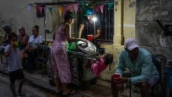 A woman buys soup from a street vendor during a power outage in Havana, Monday, Oct. 21, 2024. (AP Photo/Ramon Espinosa)