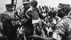 Un marine de EEUU ayuda a desembarcar a un niño cubano tras su llegada a las costas de Florida en el éxodo del Mariel. AP Photo/Fernando Yovera)