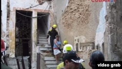 Los bomberos ayudan a evacuar a los vecinos de un edificio derrumbado en la calle Villegas de La Habana Vieja.