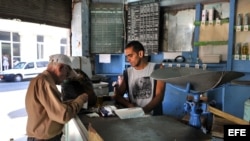 Un bodeguero vende productos racionados a un cliente en La Habana. (Archivo)