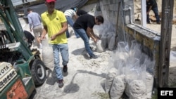 Varias personas llenan bolsas de plástico con arena para protegerse del agua de cara al huracán Irma, en Miami, Florida.