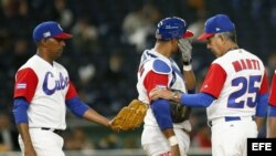 El entrenador de la selección cubana Carlos Martí (d) pasa la bola al receptor Jonder Martínez (i) en el partido entre Cuba y Holanda del IV Clásico Mundial de Béisbol.