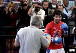 Manny Pacquiao (d) pelea con su entrenador Freddie Roach (i).