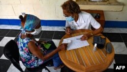 Una enfermera atiende a una anciana en una clínica de La Habana. (YAMIL LAGE / AFP)