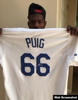 Yasiel Puig muestra una camiseta firmada por él.