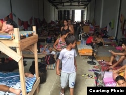 Niños en el almacén que sirve de refugio a los cubanos en Turbo, Colombia. Foto: R. Quintana.