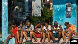 Jóvenes en La Habana en sus teléfonos celulares. (AFP/Yamil Lage).