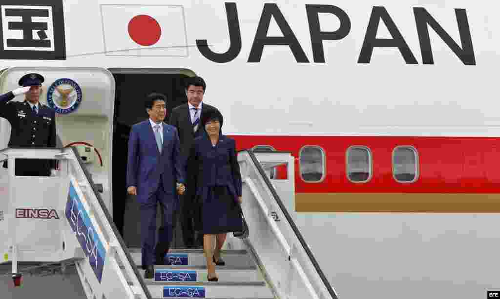 Shinzo Abe desciende de un avión con su esposa Akie.