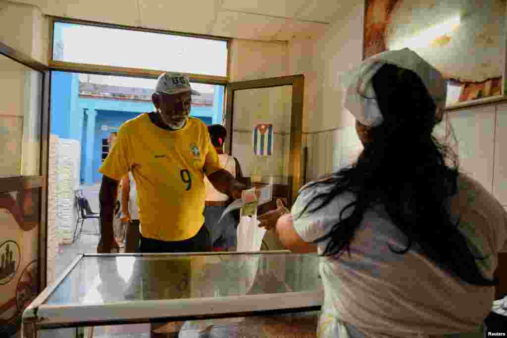 Un hombre paga en una panadería, en La Habana, Cuba 4 de septiembre de 2024. REUTERS/Norlys Pérez