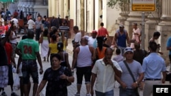 Varias personas caminan por una céntrica calle, junto a una Casa de Cambio, en La Habana (Cuba). 