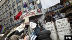 Dos milicianos prorrusos custodian la entrada de la sede del Servicio de Seguridad sobre una barricada levantada en Lugansk (Ucrania) hoy, lunes 21 de abril de 2014.