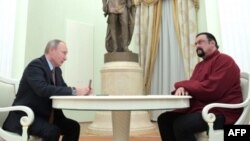 Vladimir Putin (i) con el pasaporte de Rusia para Steven Seagal