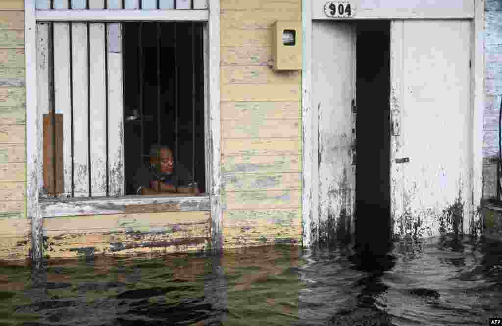 Un hombre se asoma a la ventana de su casa en una zona inundada de Batabano, provincia de Mayabeque, Cuba, el 26 de septiembre de 2024.