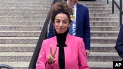 Masih Alinejad hace el signo de victoria al salir de la corte federal de Manhattan el 7 de abril de 2023, en Nueva York, después de la sentencia a una californiana por participar en un intento de secuestrarla. (AP Photo/Lawrence Neumeister).