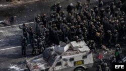 Miembros de la Guardia Nacional Bolivariana (GNB) se enfrentan a manifestantes opositores el sábado, 27 de mayo de 2017, en Caracas.