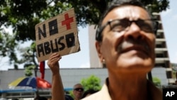 Una mujer sostiene un cartel durante protesta contra régimen de Nicolás Maduro en Caracas (Foto AP)