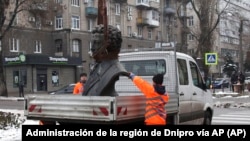 Trabajadores municipales desmantelan un busto del escritor ruso Alexander Pushkin, el viernes 16 de diciembre de 2022, en Dnipro, Ucrania.