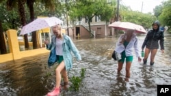 Peatones recorren la calle Montagu en Charleston, Carolina del Sur, mientras se acerca la tormenta tropical Debby, el martes 6 de agosto de 2024. (Foto AP/Mic Smith)