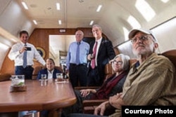 En el avión de regreso a casa, Alan Gross ve por TV la noticia de su liberación.