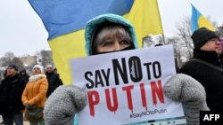 "Diga NO a Putin", pide el cartel que porta una manifestante pacífica en Ucrania el 9 de enero de 2022. (Sergei SUPINSKY/AFP).