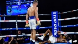 El cubano Robeisy Ramírez, izquierda, mira a Abraham Nova tras derribarlo durante el quinto asalto de un combate de boxeo de peso pluma el sábado 18 de junio de 2022, en Nueva York. Ramírez ganó en el quinto asalto. (AP Foto/Frank Franklin II)