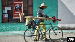 Un hombre camina con su bicicleta de la mano por una calle de Santa Clara. (Yamil Lage/AFP).